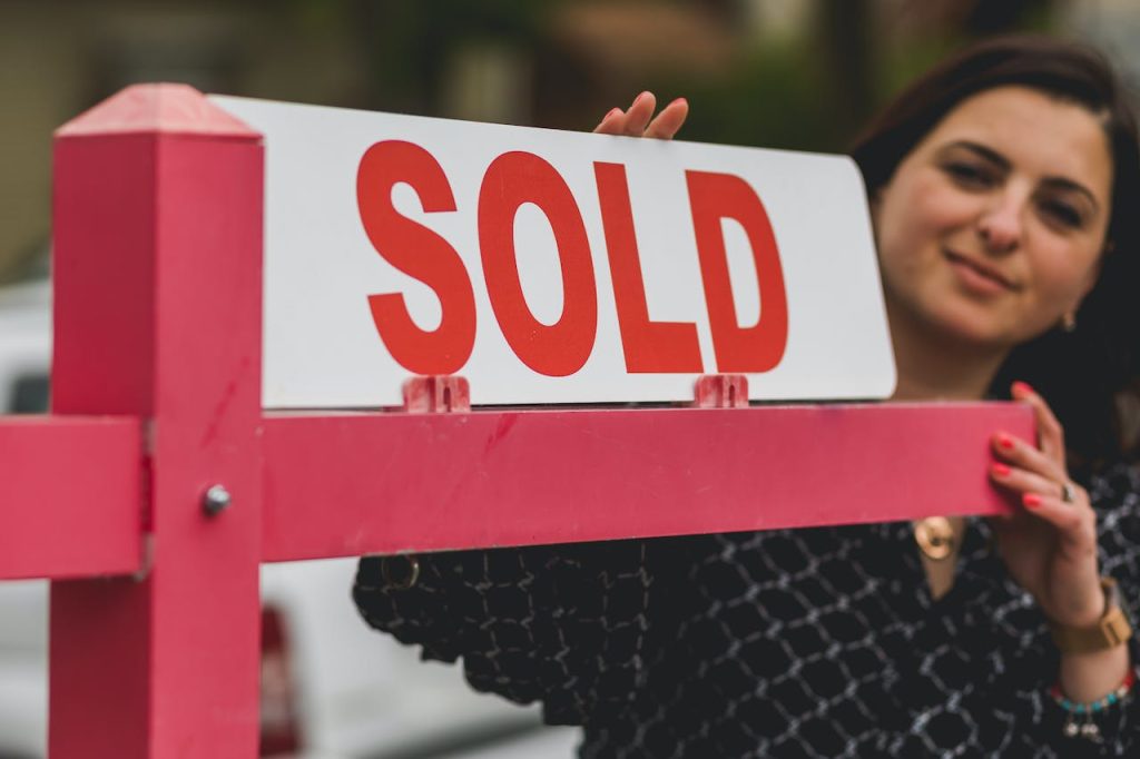 Image of a Real Estate Agent putting up a for sale sign
